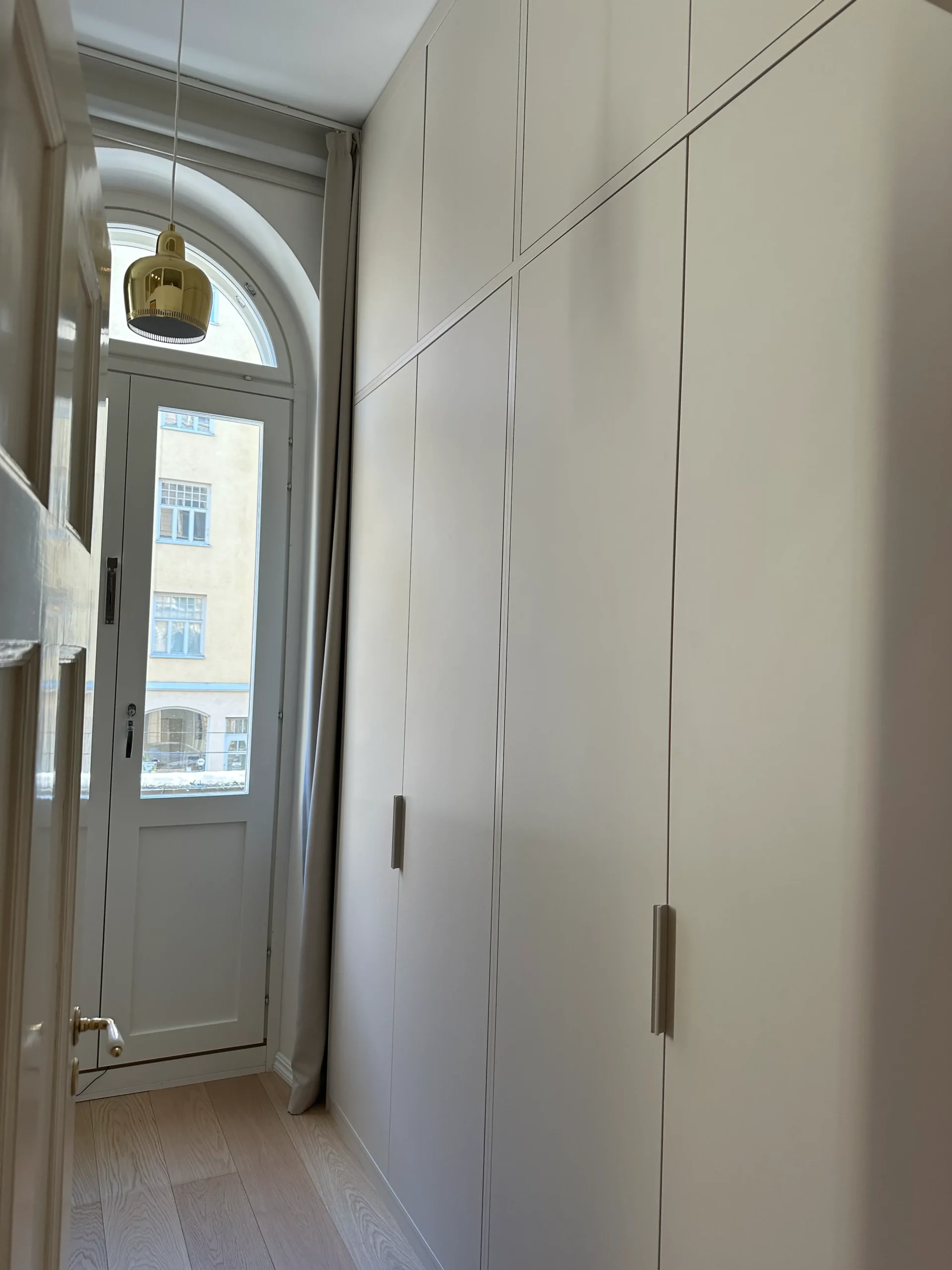 Mittatilauskaapisto huoneessa, jossa on kaari-ikkunat